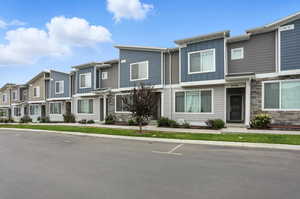 Townhome property with board and batten siding, a residential view, and stone siding