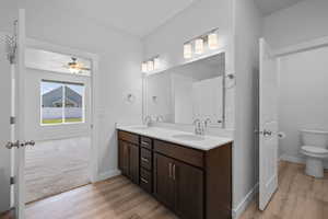Primary bathroom with double vanity, dark wood cabinets, and quartz countertops