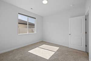 Carpeted spare room with baseboards