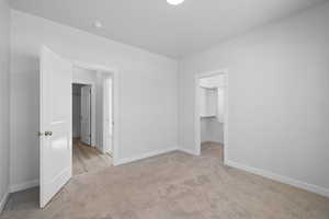 Spare bedroom with carpet and walk-in closet