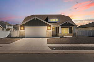 Craftsman inspired home featuring board and batten siding with stone accents, and a xeriscape front yard.