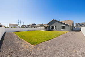 Rear view of house with a fenced backyard, stucco siding, and a patio area