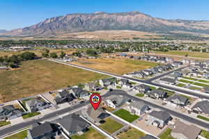 Aerial view of property and surrounding area featuring mountains and nearby suburban area