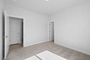 Spare bedroom with carpet and walk-in closet