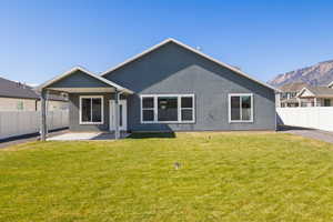 Rear view of property featuring a patio area, a fenced backyard, stucco siding, and a mountain view