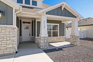 Craftsman inspired home featuring board and batten siding with stone accents, and a xeriscape front yard.