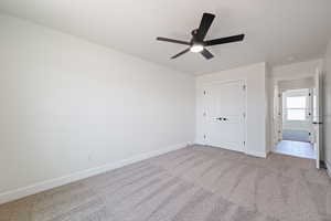 Unfurnished bedroom featuring carpet flooring, a closet, and ceiling fan