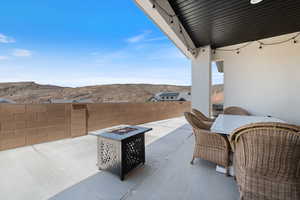 Fenced backyard with an outdoor fire pit, a mountain view, and a patio area