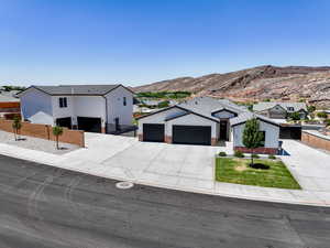 Modern inspired farmhouse featuring an attached garage, concrete driveway, a mountain view, and board and batten siding