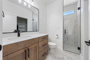 Bathroom with marble finish flooring, vanity, and a marble finish shower