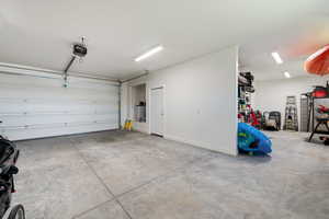Garage featuring a garage door opener and water heater