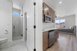 Kitchen with appliances with stainless steel finishes, plenty of natural light, light countertops, ceiling fan, and recessed lighting