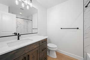 Bathroom with vanity, wood finished floors, and a shower