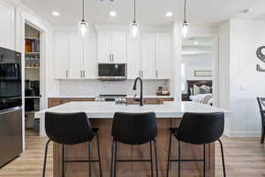 Kitchen featuring appliances with stainless steel finishes, backsplash, light countertops, and recessed lighting