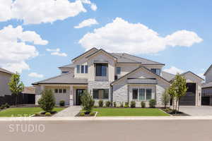 View of front of property featuring stone siding, a tile roof, driveway, and board and batten siding