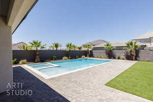 View of swimming pool with a fenced backyard, a patio area, and a pool with connected hot tub