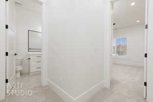 Hallway with recessed lighting and light colored carpet