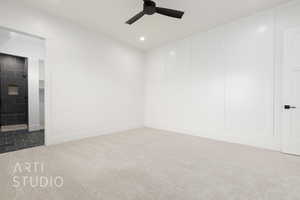 Carpeted spare room featuring a ceiling fan, recessed lighting, and a decorative wall
