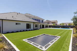 Back of house with stucco siding, a fenced backyard, and a patio area