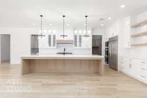 Kitchen featuring built in appliances, open shelves, light countertops, decorative backsplash, and recessed lighting