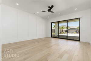 Empty room with a decorative wall, light wood-style flooring, ceiling fan, and recessed lighting