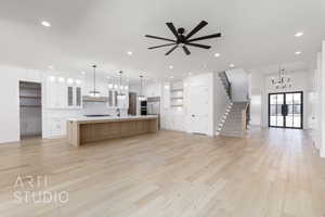 Kitchen with open floor plan, decorative backsplash, a chandelier, light countertops, and light wood-type flooring