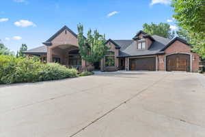 View of front of house featuring brick siding, driveway, a garage, and roof with shingles