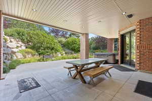 View of patio with a hot tub, outdoor dining space, and french doors