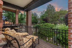 Wooden terrace with outdoor dining area and view of wooded area