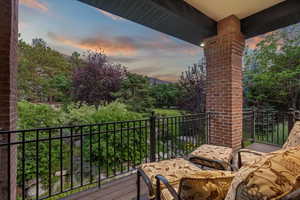 Balcony at dusk featuring view of scattered trees