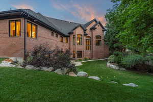 Rear view of property featuring brick siding and a lawn