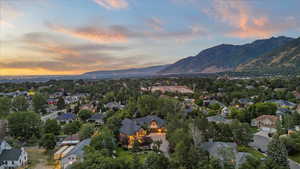 Aerial view of property and surrounding area with a mountainous background and nearby suburban area
