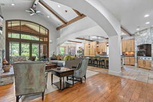 Living area with ceiling fan, beamed ceiling, arched walkways, high vaulted ceiling, and recessed lighting