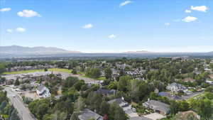 Aerial overview of property's location with a mountainous background and nearby suburban area