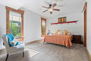 Carpeted bedroom with baseboards and ceiling fan