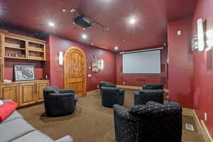 Carpeted home theater with recessed lighting and baseboards
