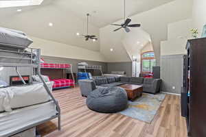 Bedroom with lofted ceiling, light wood-type flooring, and recessed lighting
