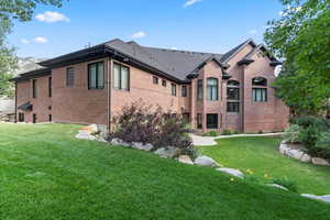 View of home's exterior featuring brick siding and a yard
