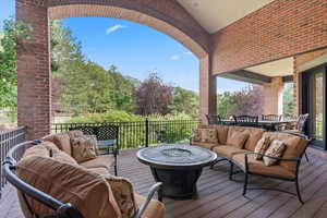 Wooden terrace with an outdoor living space with a fire pit and outdoor dining space