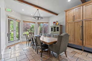 Dining space with recessed lighting, beam ceiling, stone tile floors, and a chandelier