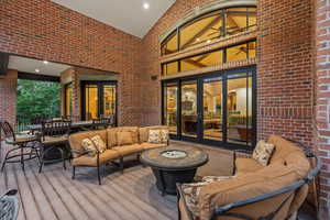 Wooden terrace with an outdoor living space with a fire pit, outdoor dining area, and french doors