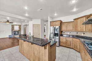 Kitchen with stainless steel appliances, open floor plan, a breakfast bar, ceiling fan, and recessed lighting