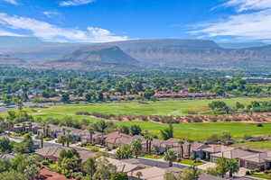 Aerial view of residential area featuring a mountain backdrop and a local golf course