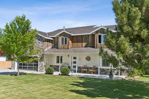 Rear view of property with stone siding, a yard, and a metal roof