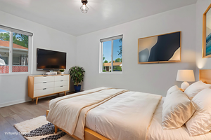 Bedroom featuring multiple windows and light wood-style flooring