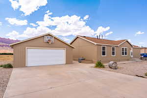 View of front of house with a garage, an outbuilding, and a mountain view