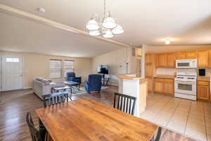 Dining room featuring vaulted ceiling, a chandelier, and light wood-type flooring