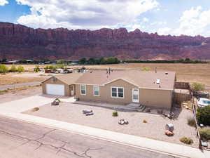 View of front of property featuring a mountain view, driveway, and a shingled roof