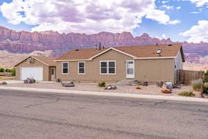 Manufactured / mobile home with a mountain view, roof with shingles, driveway, and a garage