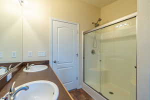 Bathroom with a stall shower and double vanity
